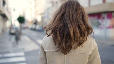 Young caucasian woman standing backwards at street