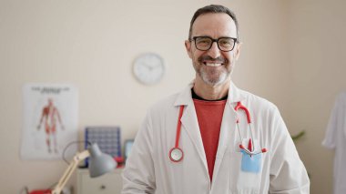 Middle age man doctor smiling confident standing at clinic