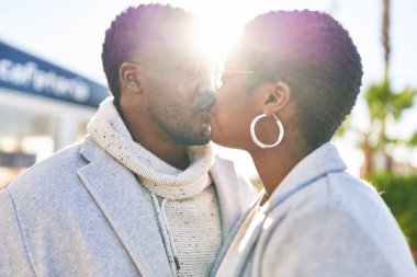 Erkek ve kadın bir arada durarak gülümsüyor.