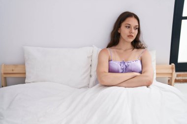 Young woman stressed sitting on bed at bedroom