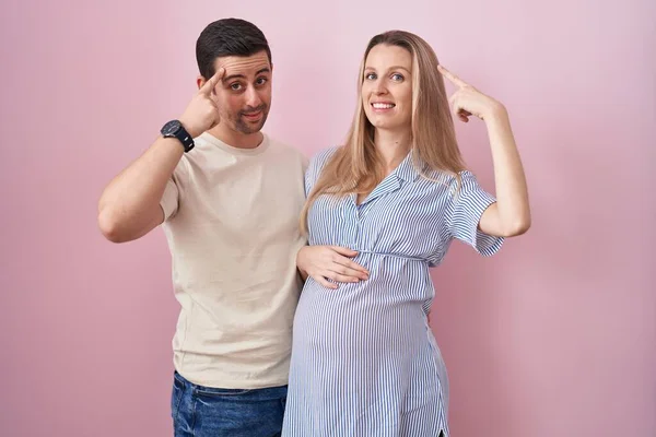 Casal Jovem Esperando Bebê Sobre Fundo Rosa Sorrindo Apontando Para — Fotografia de Stock