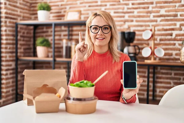 Blonde Frau Beim Essen Essen Zum Mitnehmen Zeigt Smartphone Bildschirm — Stockfoto