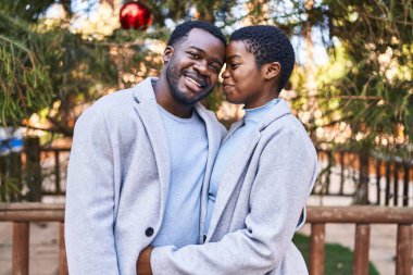 Kadın ve erkek parkta birbirlerine sarılıyorlar.