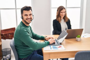 Kadın ve erkek, ofiste çalışan laptopu kullanarak çağrı merkezi ajanını arıyor.