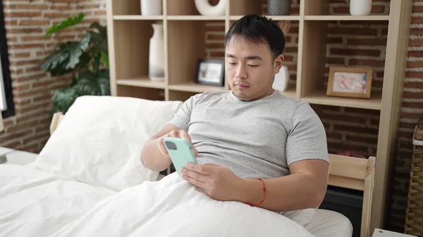 Jeune Homme Chinois Utilisant Smartphone Assis Sur Lit Dans Chambre — Photo