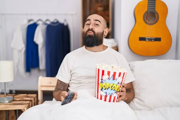 Young Hispanic Man Beard Tattoos Eating Popcorn Bed Looking Camera — Foto de Stock
