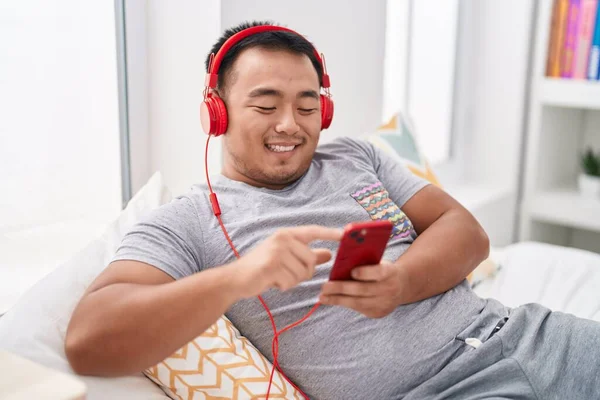 Mladý Číňan Poslouchá Hudbu Ležící Posteli Ložnici — Stock fotografie
