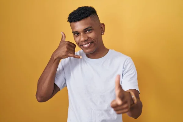 Young Hispanic Man Standing Yellow Background Smiling Doing Talking Telephone —  Fotos de Stock