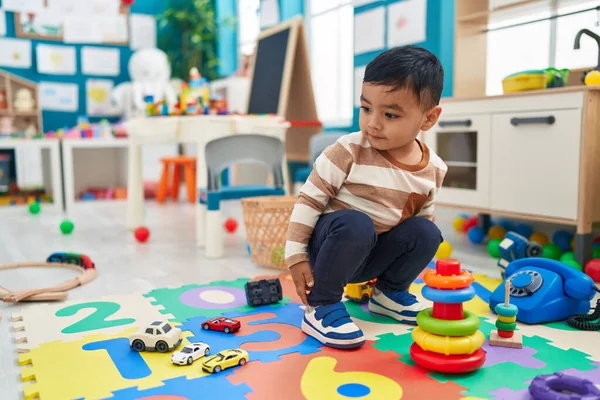 可敬的是 他的惊慌失措的幼儿在幼儿园的地板上玩圈圈游戏 — 图库照片