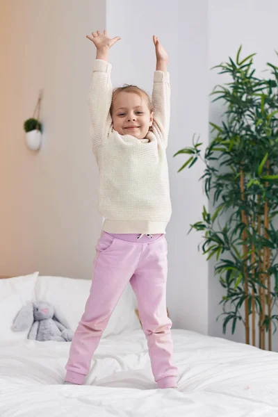 Adorable Blonde Girl Standing Bed Hands Raised Bedroom — Stockfoto