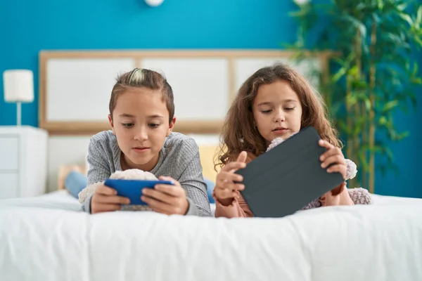 Two Kids Using Smartphone Touchpad Lying Bed Bedroom — Fotografia de Stock