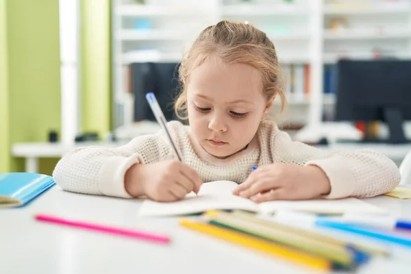 Defterine Yazı Yazan Sevimli Sarışın Kız Öğrenci Sınıftaki Masada Oturuyor — Stok fotoğraf