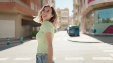 Young woman smiling confident dancing at street