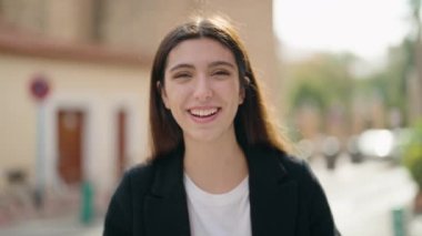 Sokakta kendine güvenen genç İspanyol kız gülümsüyor.