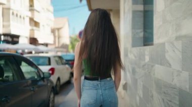 Sokakta kollarını kavuşturmuş genç, güzel İspanyol bir kadın.