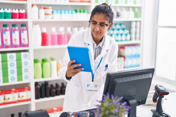 Young Beautiful Hispanic Woman Pharmacist Using Touchpad Computer Working Pharmacy — Stok fotoğraf