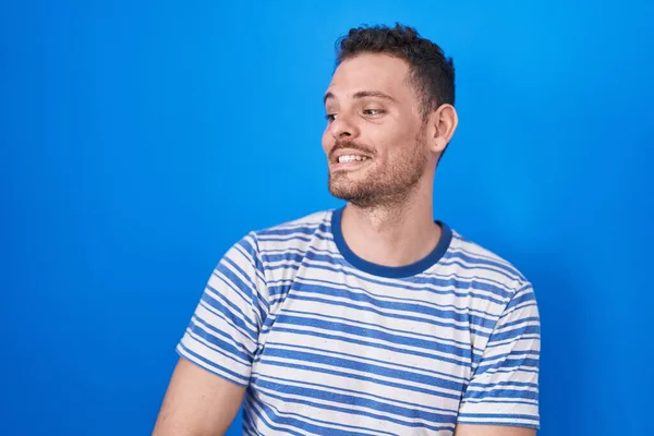 Young Hispanic Man Standing Blue Background Looking Away Side Smile — 图库照片