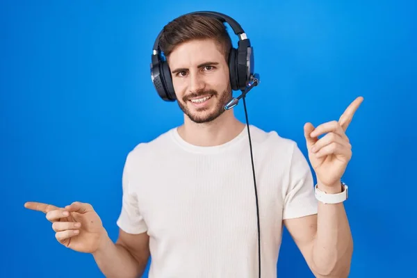 Hispanic Man Beard Listening Music Wearing Headphones Smiling Confident Pointing — Stok fotoğraf