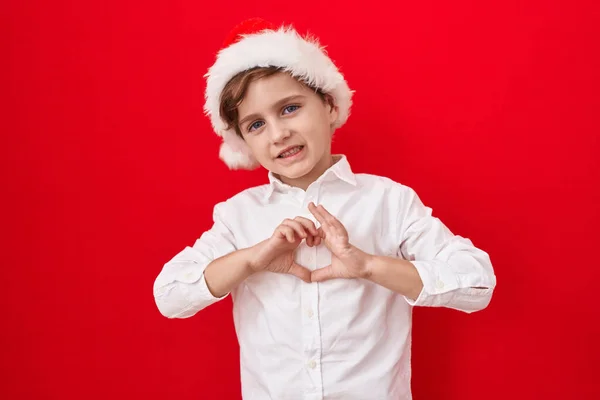 Little Caucasian Boy Wearing Christmas Hat Red Background Smiling Love — Stock Photo, Image
