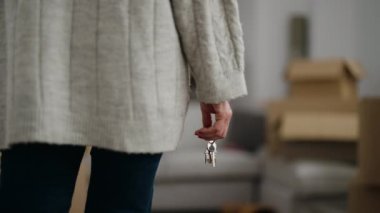 Middle age woman holding key of house at new home