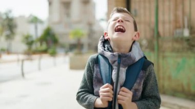 portrait of a boy screaming in the city