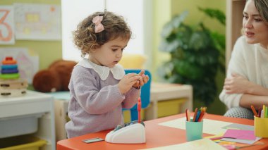 Teacher and toddler playing at kindergarten