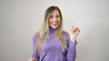 Young blonde woman smiling confident dancing over isolated white background