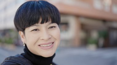 Young chinese woman smiling confident standing at street