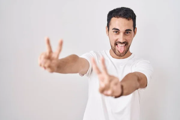 Handsome Hispanic Man Standing White Background Smiling Tongue Out Showing — Fotografia de Stock