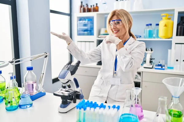 Mulher Loira Meia Idade Trabalhando Laboratório Cientista Espantado Sorrindo Para — Fotografia de Stock