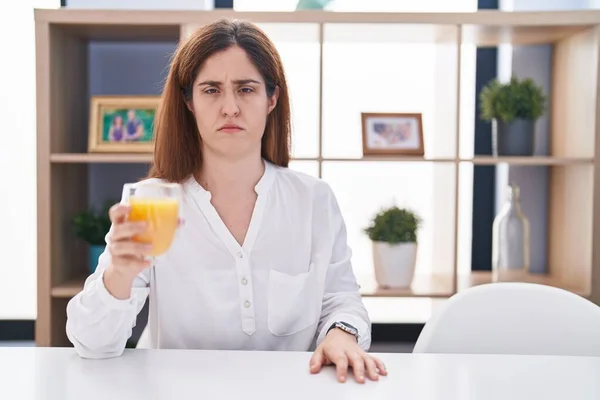 問題のために動揺眉をひそめ オレンジジュース懐疑的かつ神経のガラスを飲むブルネットの女性 否定的な人 — ストック写真