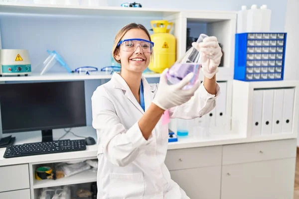 研究室で液体を測定する若いヒスパニック系女性科学者 — ストック写真