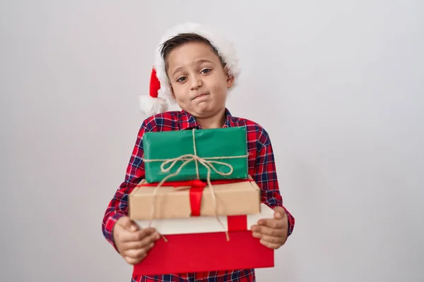 Little Hispanic Boy Wearing Christmas Hat Holding Presents Clueless Confused — 图库照片