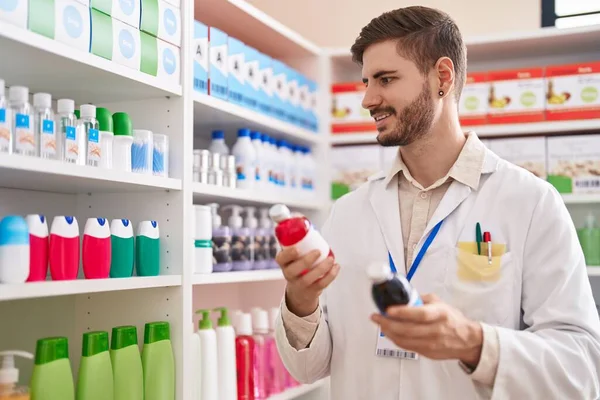 Young Caucasian Man Pharmacist Smiling Confident Holding Medication Bottles Pharmacy — Stockfoto
