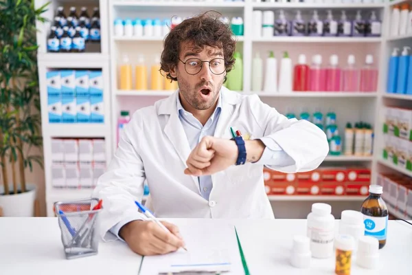 Hispanic Young Man Working Pharmacy Drugstore Looking Watch Time Worried — Stock fotografie