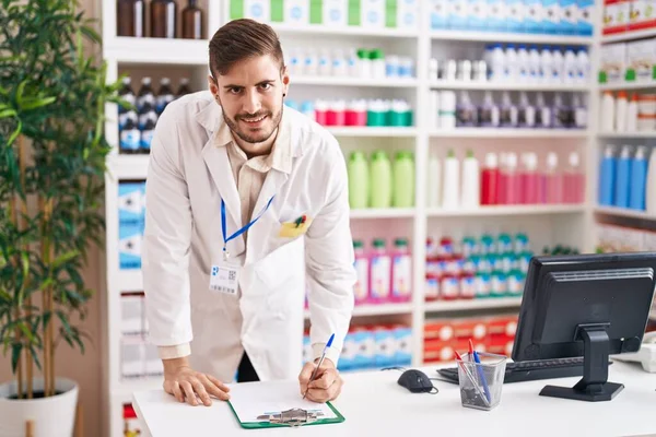 Young Caucasian Man Pharmacist Smiling Confident Writing Document Pharmacy — 스톡 사진