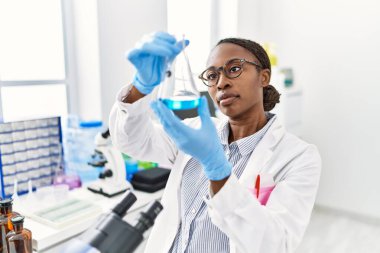 African american woman scientist holding test tube at laboratory
