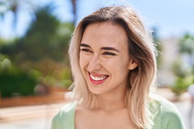 Young woman smiling confident looking to the side at park