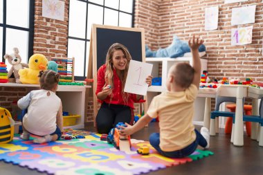 Erkek ve kız çocuklu öğretmen, anaokulunda matematik dersi alıyor.
