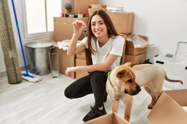 Genç İspanyol kadın gülümsüyor. Yeni evin anahtarını elinde tutuyor.