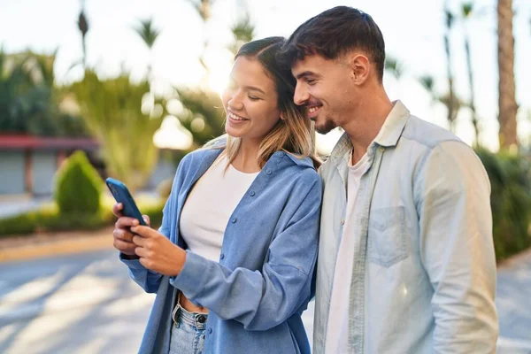 年轻男女夫妇在街上用智能手机充满自信地微笑着 — 图库照片