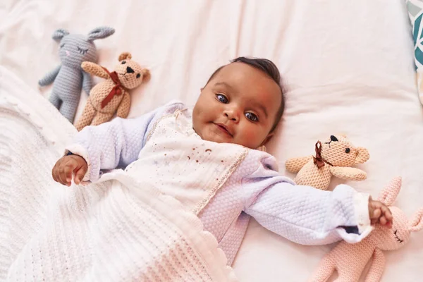 非洲裔美国婴儿躺在床上 卧室里挂着玩具娃娃 — 图库照片
