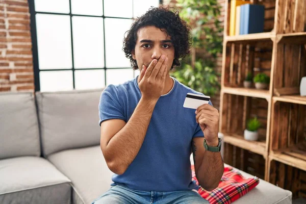 Hispanic Man Curly Hair Holding Credit Card Covering Mouth Hand — Foto Stock