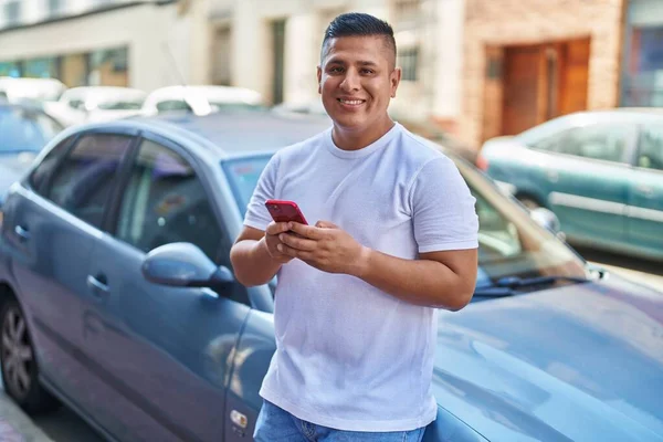 Ung Latin Man Med Smartphone Lutar Sig Mot Bilen Gatan — Stockfoto
