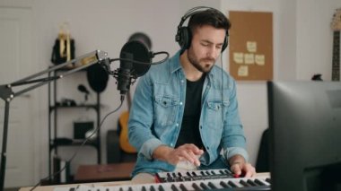 Genç İspanyol müzisyen müzik stüdyosunda piyano çalıyor.