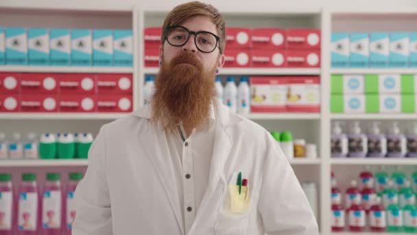 年轻的红头发男子药剂师带着自信的笑容在药店拿着信用卡 — 图库视频影像