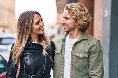 Erkek ve kadın bir arada durarak gülümsüyor.