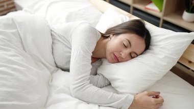 Genç, güzel, İspanyol bir kadın yatakta uzanıyor.