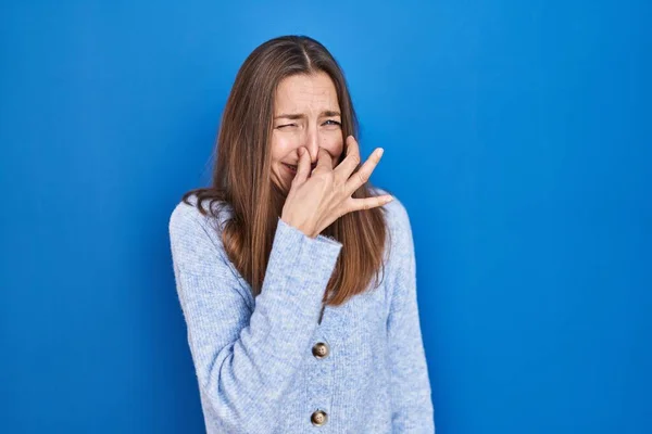 Young Woman Standing Blue Background Smelling Something Stinky Disgusting Intolerable — ストック写真