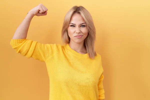 Young Caucasian Woman Wearing Yellow Sweater Strong Person Showing Arm — Stockfoto